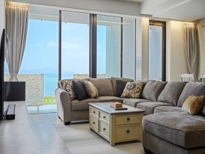 uma sala de estar com um sofá e uma mesa em Onna Resort em Nago