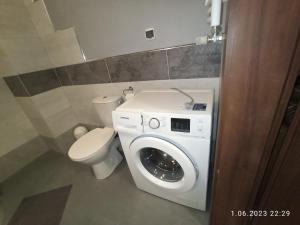 a bathroom with a washing machine and a toilet at Reda-Centrum in Reda