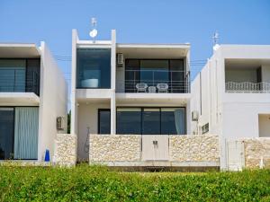 an apartment building with a fence in front of it at Onna Resort 海まで徒歩0秒 最大12名宿泊可 オーシャンビュー貸切ヴィラ in Nago