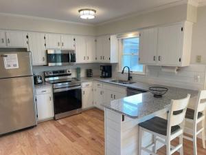 uma cozinha com armários brancos e electrodomésticos de aço inoxidável em Charming Family Home 7 mins to Beach Dog Friendly em Ocean City