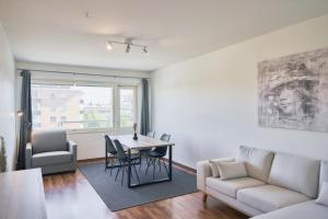een woonkamer met een tafel en een bank bij Norden Homes Turku 2-Bedroom Nordic Apartment in Turku