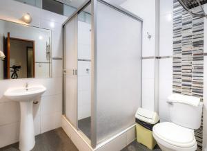 een badkamer met een douche, een toilet en een wastafel bij Hotel Portada Del Sol in Trujillo