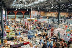 un marché avec des gens se promenant dans un bâtiment dans l'établissement Three-Storey, Renovated 1890s Heritage Home in Spitalfields Market, à Londres