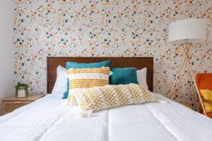 1 dormitorio con cama blanca y papel pintado con motivos florales en Retro Retreat renovated 2BR, desk, no chore list!, en Kingston