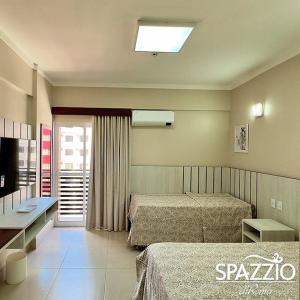 Cette chambre comprend deux lits et une télévision. dans l'établissement Spazzio diRoma acesso diRoma Acqua Park gratuito Star Temporada, à Caldas Novas