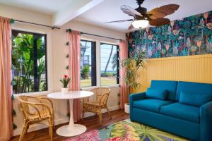 a living room with a blue couch and a table at MaKai Sunset Inn in Lahaina