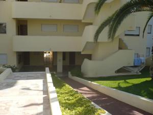 a building with a palm tree in front of it at Happydreams apartment in Albufeira in Albufeira