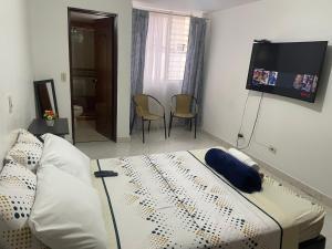 a living room with a bed and a tv at M&N Alojamiento es una habitación en un apto in Medellín