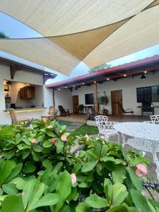 an outdoor patio with awning and plants and flowers at Hostal DEYLUWIN in Juayúa