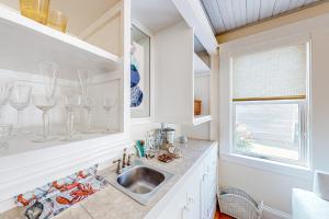 a kitchen with a sink and wine glasses on the counter at Bees Knees House in Boothbay Harbor