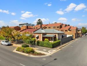 a building on a street with a car parked in front at Azami - Charming Gilbert Cottage in Adelaide