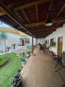 an outdoor patio with a wooden ceiling and a deck at Hostal DEYLUWIN in Juayúa