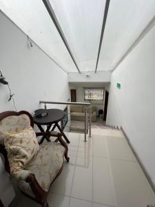 a living room with a table and a chair at Hotel Tempus in Pasto