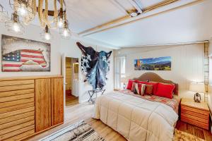 a bedroom with a large bed and a chandelier at Cowboy Cabin Ranch in Colorado Springs