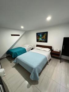 ein Schlafzimmer mit 2 Betten und einem Wandgemälde in der Unterkunft Hotel Tempus in Pasto