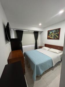 a bedroom with a bed and a television in it at Hotel Tempus in Pasto