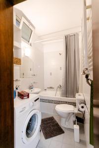 a bathroom with a washing machine and a toilet at Hermes Modern Apartment in Alexandroupoli