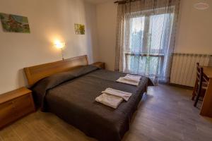 a bedroom with a bed with two towels on it at Apartments by the sea Supetarska Draga - Gornja, Rab - 21380 in Rab
