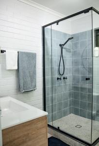 een badkamer met een douche en een wastafel bij Michaels by the Sea in Yeppoon