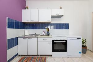 a white kitchen with white cabinets and blue tiles at Apartments by the sea Tkon, Pasman - 21391 in Tkon