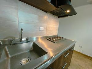 uma cozinha com um lavatório de aço inoxidável e um fogão em Los Ríos em Pereira