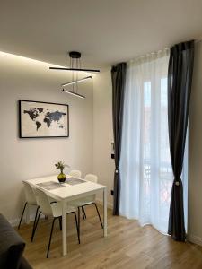 Biały stół i krzesła w pokoju z oknem w obiekcie Luxury Downtown - Milan MF Apartments w Mediolanie