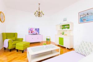 a living room with a couch and a chair and a table at Family friendly house with a swimming pool Plano, Trogir - 21403 in Prgomet