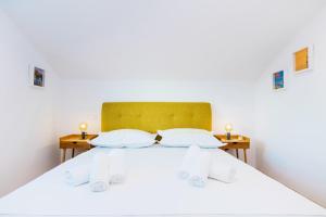 a bedroom with a white bed with two night stands at Family friendly house with a swimming pool Plano, Trogir - 21403 in Prgomet +17 photos