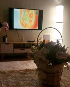 - Cesta de flores en la sala de estar con TV en WP Boss Studio en Kepala Batas
