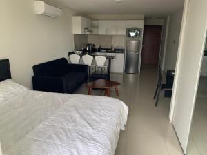 a bedroom with a bed and a living room with a kitchen at Apartamento JC Santa Cruz Norte in Santa Cruz de la Sierra