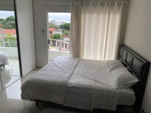 a bedroom with a bed and a large window at Apartamento JC Santa Cruz Norte in Santa Cruz de la Sierra