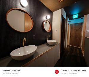 名古屋市にある2023年6月開業 サカエ ゲストハウスのバスルーム(洗面台2台、壁に鏡2つ付)