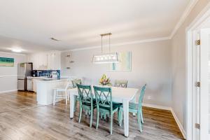 彭薩科拉的住宿－Flood Reef Retreat - Blue Crab Cottage，厨房以及带白色桌椅的用餐室。