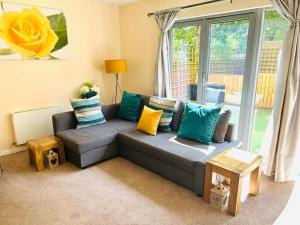 salon z szarą kanapą i kolorowymi poduszkami w obiekcie Cakemuir Detached House, 3 Bed, Free parking &Private Garden w Edynburgu