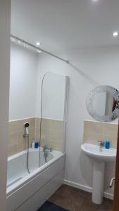 a bathroom with a bath tub and a sink at Cakemuir Detached House, 3 Bed, Free parking &Private Garden in Edinburgh
