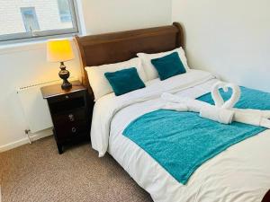 ein Schlafzimmer mit einem großen Bett mit einer blauen Decke in der Unterkunft Cakemuir Detached House, 3 Bed, Free parking &Private Garden in Edinburgh