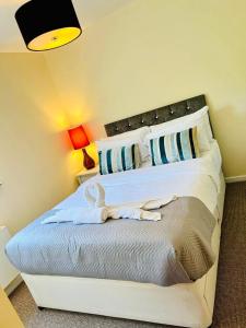 ein Schlafzimmer mit einem großen Bett mit weißer Bettwäsche in der Unterkunft Cakemuir Detached House, 3 Bed, Free parking &Private Garden in Edinburgh