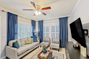 uma sala de estar com um sofá e uma ventoinha de tecto em Casa Del Sol em San Antonio