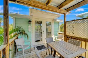 een terras met een houten tafel en stoelen op een huis bij Casa Del Sol C in Bradenton Beach