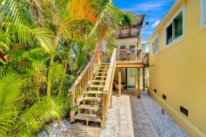 een trap naar een huis met palmbomen bij Casa Del Sol C in Bradenton Beach
