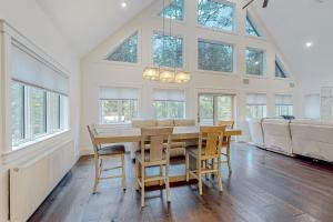 a dining room with a table and chairs and windows at Webb River House in Rumford