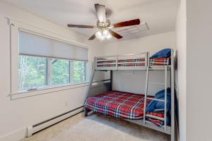 a bedroom with two bunk beds and a ceiling fan at Webb River House in Rumford