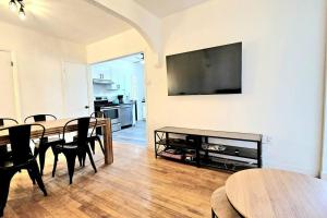 a living room with a table and a television on a wall at WOW - 2CH Vieux-Limoilou à proximité Vieux-QC in Quebec City