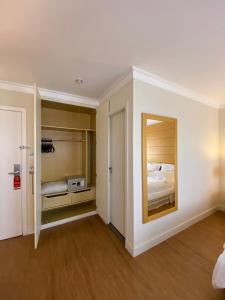 uma sala com um quarto com um espelho e uma cama em Hotel Aeroporto Congonhas em São Paulo