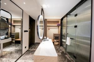 bagno con lavandino e specchio di UrCove by HYATT Shenzhen Luohu a Shenzhen