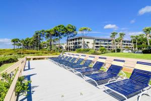 a row of blue lounge chairs on a deck at Sea Side Villas 108 in Hilton Head Island