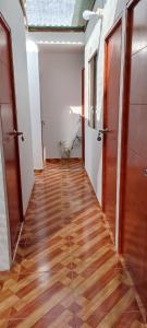 an empty hallway with wooden floors and doors at POSADA MIS 3 BENDICIONES in Paracas