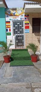 una casa con due piante in vaso davanti a una porta di POSADA MIS 3 BENDICIONES a Paracas