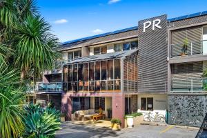 an exterior view of a building with palm trees at Park Ridge Retreat in Gerringong