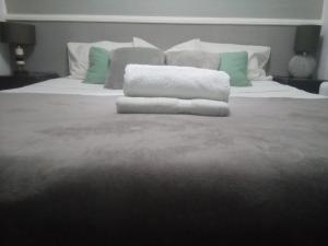 Una cama con dos toallas encima. en Guest House Sintra, en Queluz